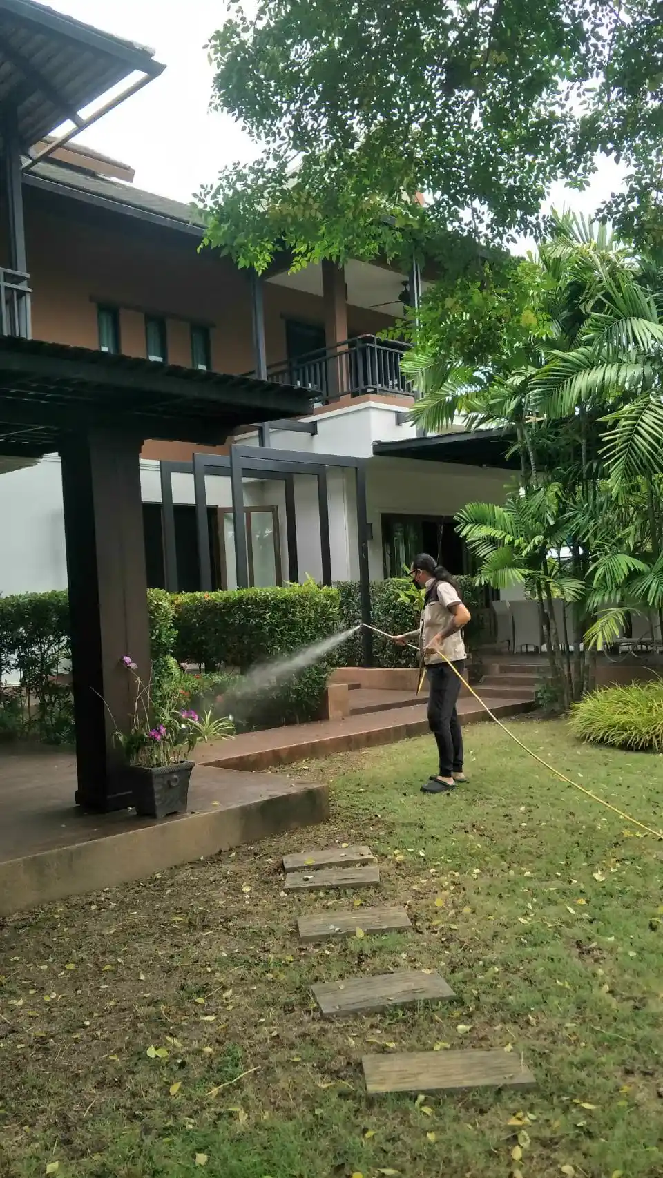 Green Nano Thai technician applying termite treatment inside a Chiang Mai home